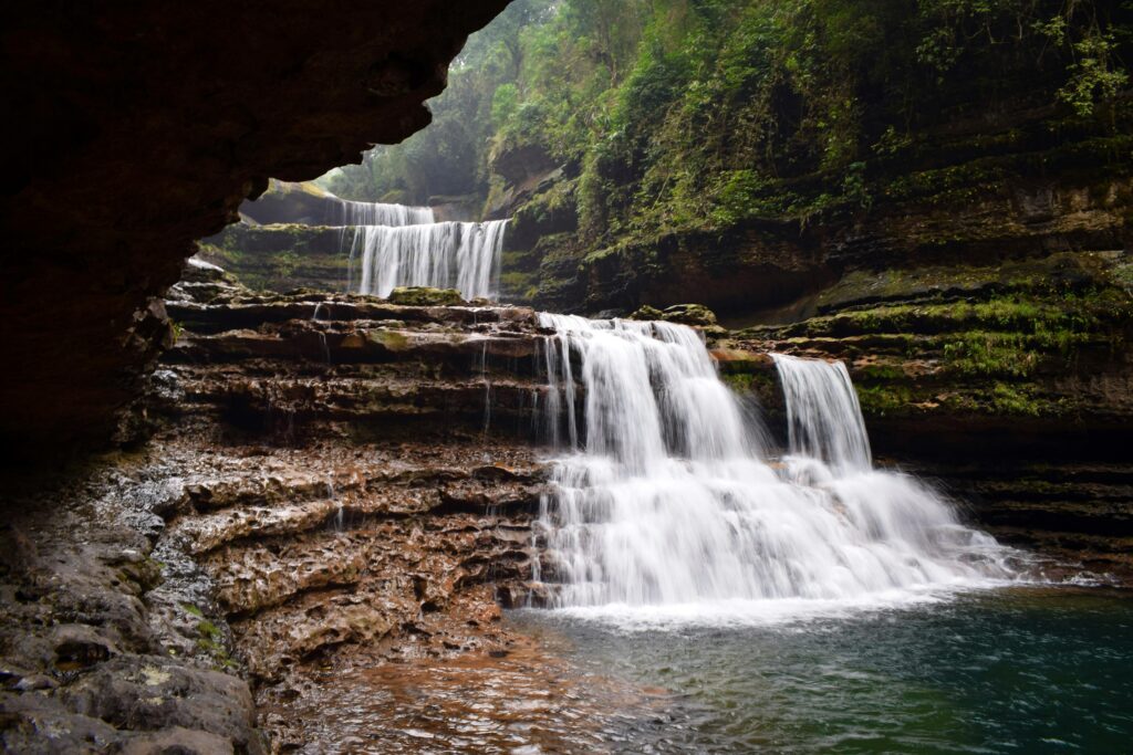 Beautiful waterfall in Cherrapunji, India surrounded by lush greenery.