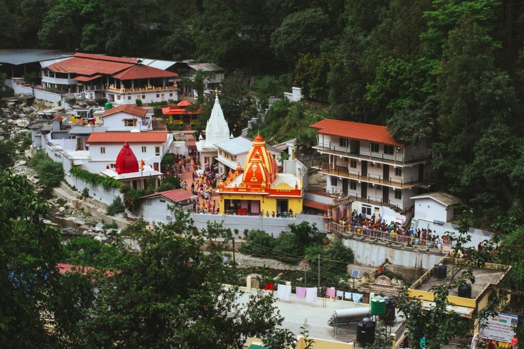 A stunning aerial shot of the iconic Kainchi Dham temple enveloped by lush forests in India.