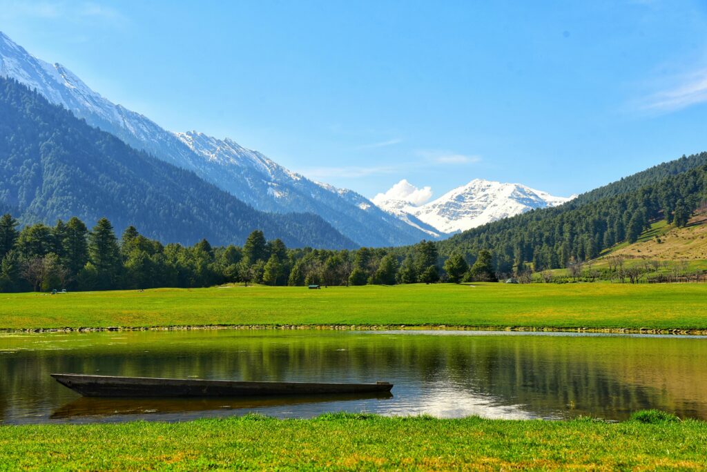 Scenic View of a Green Valley and Snowcapped Mountains in the Distance