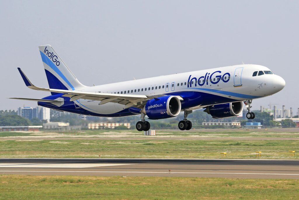 IndiGo plane taking off from an airport runway during the day.