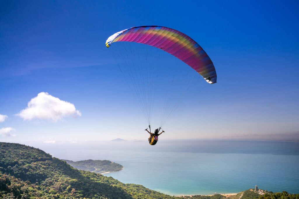 Experience the thrill of paragliding over stunning ocean views and lush landscapes.