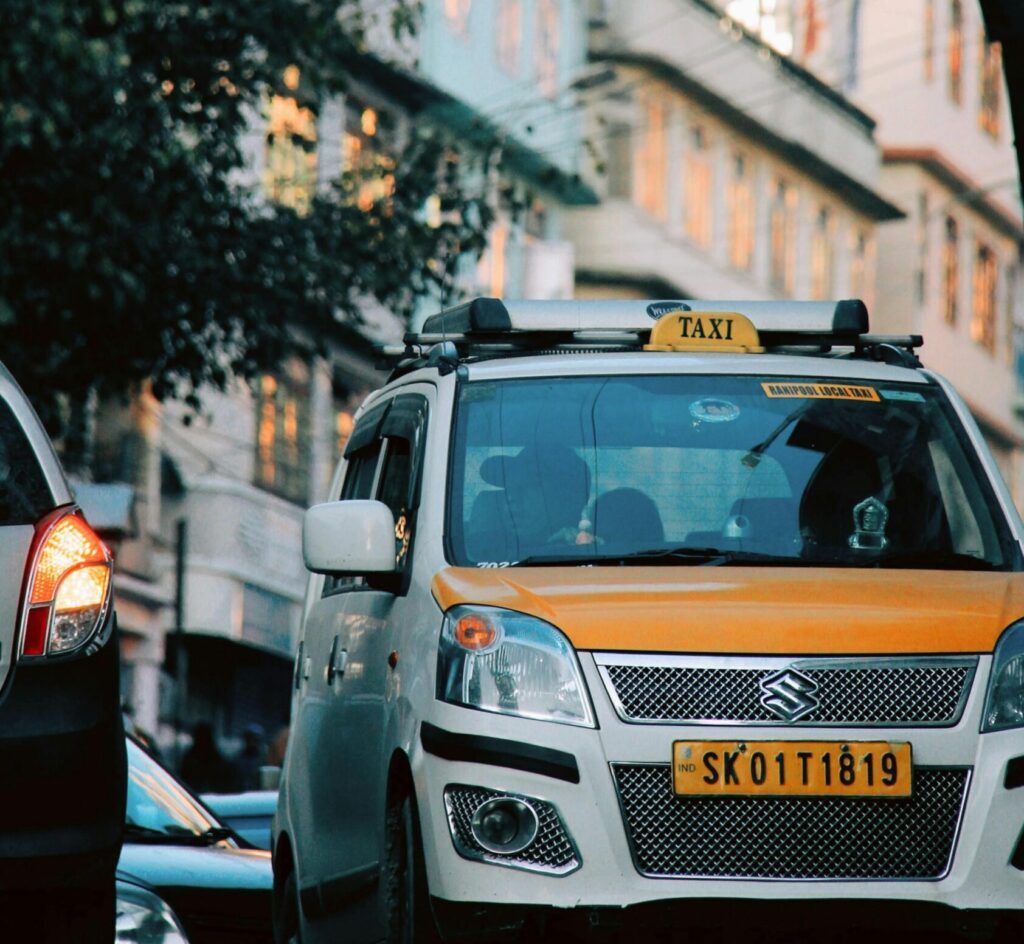 Suzuki taxi navigates through busy urban streets of Gangtok, India.