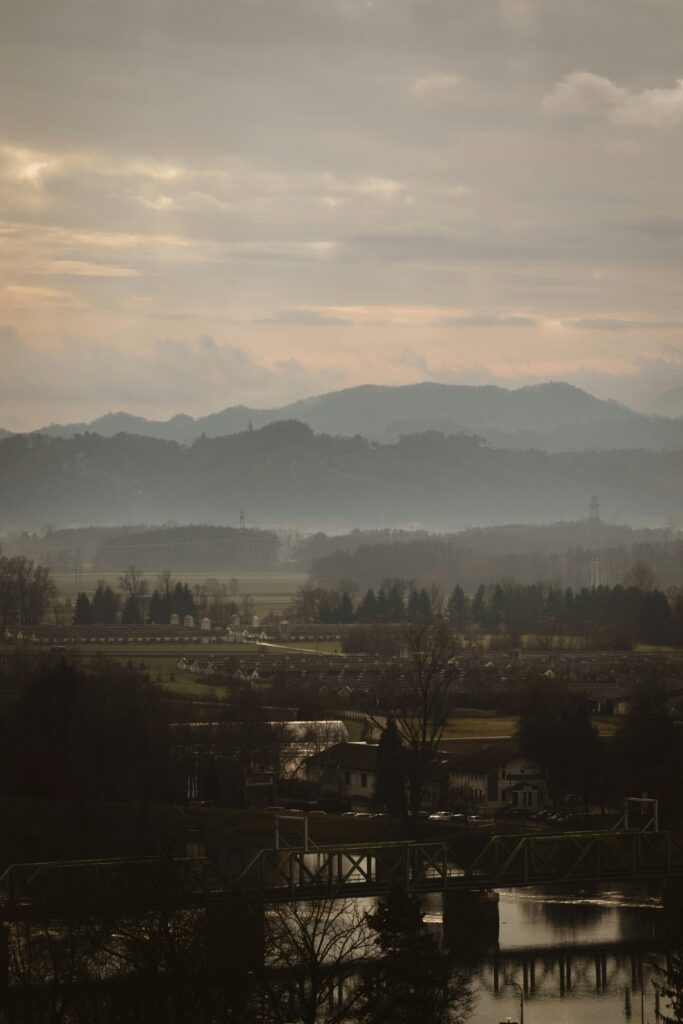 A tranquil view of the misty landscape of Ptuj, Slovenia with distant hills.