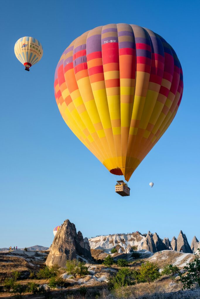 Vibrant hot air balloons soaring over Cappadocia's unique rock formations in Nevşehir, Turkey.