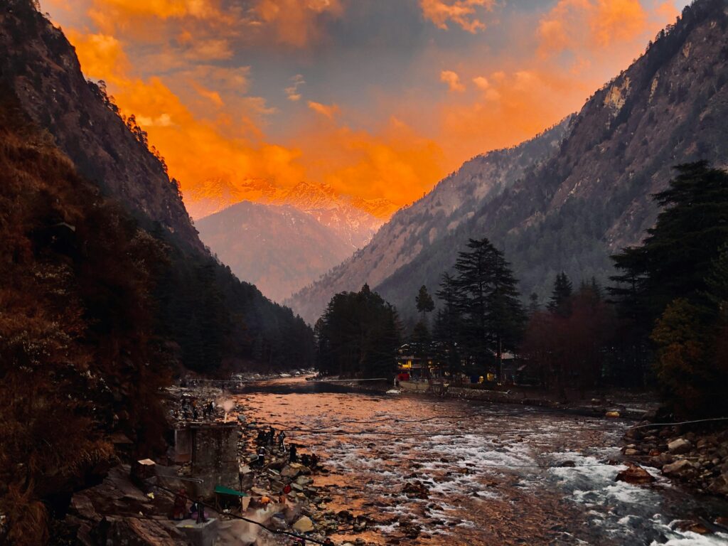 A stunning sunset view over a mountain river surrounded by dramatic peaks.